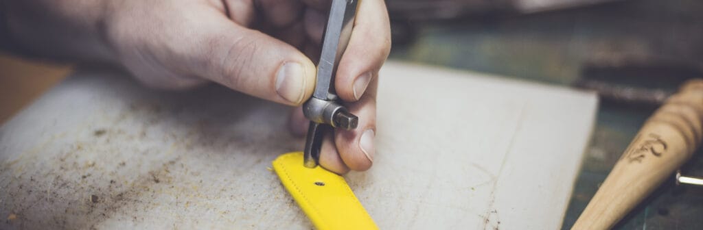 Manos cortando papel con tijeras y regla