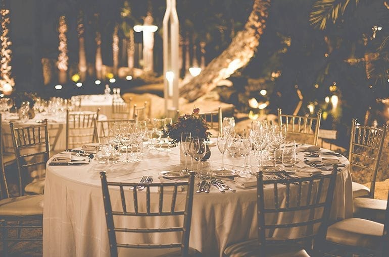 Mesa elegante con mantel blanco y sillas de chiavari