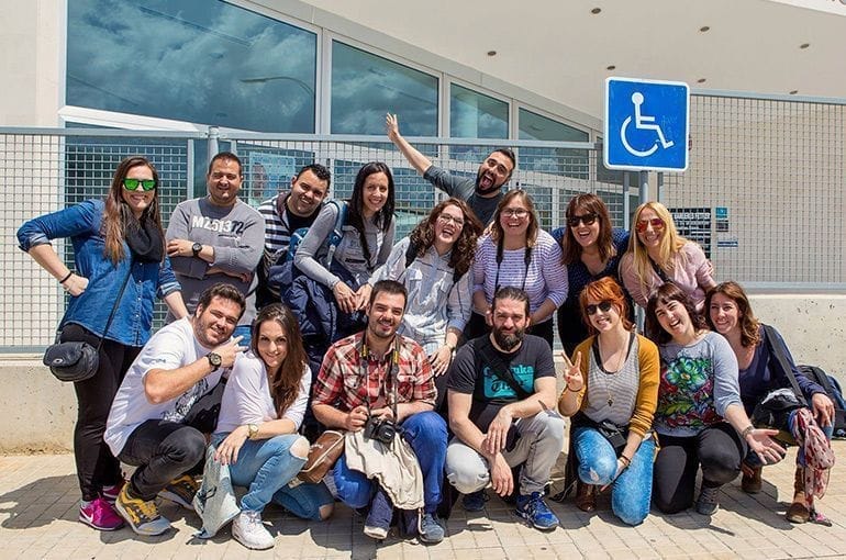 Grupo de personas posando frente a un edificio moderno.